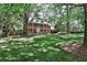 Classic brick home nestled among mature trees, showcasing a sprawling lawn and inviting landscaping at 2121 Ponce De Leon Ne Ave, Atlanta, GA 30307