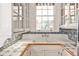 Farmhouse style kitchen sink with blue and white tile backsplash and white cabinetry at 2121 Ponce De Leon Ne Ave, Atlanta, GA 30307