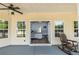 Relaxing back porch with windows looking into a living area and a wooden rocking chair at 3012 Keeneland Blvd, Mcdonough, GA 30252