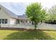 Spacious backyard featuring a well-manicured lawn, mature tree, and a white picket fence at 3012 Keeneland Blvd, Mcdonough, GA 30252