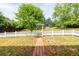 Spacious backyard with a well-kept lawn, mature trees, and a charming white picket fence at 3012 Keeneland Blvd, Mcdonough, GA 30252