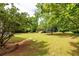 Expansive backyard with lush lawn, mature trees, and a wooden deck, ideal for outdoor enjoyment at 3012 Keeneland Blvd, Mcdonough, GA 30252