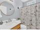 Updated bathroom with a modern vanity, round mirror, and unique shower curtain at 3012 Keeneland Blvd, Mcdonough, GA 30252