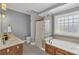 Bright bathroom featuring a bathtub, glass shower, and marble countertops at 3012 Keeneland Blvd, Mcdonough, GA 30252