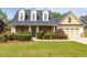 Charming home with stone accents, dormer windows, manicured lawn, and attached two-car garage at 3012 Keeneland Blvd, Mcdonough, GA 30252