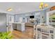 Open concept kitchen and living room with hardwood floors and a stone fireplace at 3012 Keeneland Blvd, Mcdonough, GA 30252