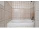 A bathroom bathtub with white trim and beige tile surround at 3664 Satellite Ter, Ellenwood, GA 30294