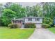 Charming two-story home with a well-manicured lawn and mature trees surrounding the property at 3664 Satellite Ter, Ellenwood, GA 30294