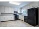 Kitchen featuring black appliances, white cabinets, and neutral countertops at 3664 Satellite Ter, Ellenwood, GA 30294