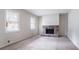Bright living room featuring neutral carpet, a stone fireplace, and natural light from large windows at 3664 Satellite Ter, Ellenwood, GA 30294
