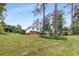 Backyard view of home with large lawn, trees, and a garden at 1619 Folkstone Ne Rd, Brookhaven, GA 30329