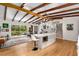 Open kitchen with an island featuring a built-in microwave, wooden beams, and patio access at 1619 Folkstone Ne Rd, Brookhaven, GA 30329