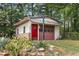View of outbuilding with red doors, surrounded by greenery at 1619 Folkstone Ne Rd, Brookhaven, GA 30329
