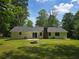 Exterior rear of home with a large grass-covered yard with a fire pit at 2799 Mockingbird Cir, Duluth, GA 30096