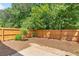 A view of the backyard with a privacy fence, mature landscaping, and small stone patio at 3022 Kentmere Dr, Cumming, GA 30040
