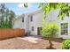 A view of the backyard with a privacy fence, mature landscaping, and concrete patio extending from sliding glass doors at 3022 Kentmere Dr, Cumming, GA 30040