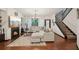 Bright living room features a fireplace, modern lighting, plush seating, and stairs to the upper level at 4430 Cedar Bridge Walk, Suwanee, GA 30024