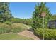 View of a walking trail surrounded by green trees and foliage, next to a trail sign at 4430 Cedar Bridge Walk, Suwanee, GA 30024