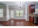 Bright breakfast nook with elegant lighting, wood floors, wainscoting, and views of the backyard through a window and glass door at 535 Pierpoint Dr, Atlanta, GA 30331