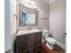 Elegant powder room featuring a granite-topped vanity, framed mirror, stylish light fixture and tile flooring at 535 Pierpoint Dr, Atlanta, GA 30331