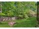 Backyard featuring a lush lawn, mature trees, and a wooden fence creating a private and serene outdoor space at 545 Creek Landing Ln, Alpharetta, GA 30005