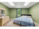 Bedroom boasts a bed, dresser with a mirror, carpet flooring, and a window, all bathed in warm light at 545 Creek Landing Ln, Alpharetta, GA 30005