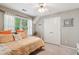 Cozy bedroom with a ceiling fan, bright window, neutral paint, and comfortable-looking patterned bedspread at 545 Creek Landing Ln, Alpharetta, GA 30005