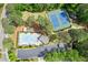 Aerial view showcases the tennis courts and community pool, surrounded by beautiful green trees at 545 Creek Landing Ln, Alpharetta, GA 30005