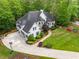 Aerial view of a luxurious home with a large driveway, well-manicured lawn, professional landscaping, and a three-car garage at 560 Indigo Dr, Roswell, GA 30075