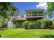 Sprawling backyard featuring mature trees, green grass, a deck, and a screened porch, creating a serene outdoor oasis at 560 Indigo Dr, Roswell, GA 30075