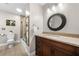 Bathroom featuring a tiled shower, granite countertop, and decorative mirror offers a stylish space at 560 Indigo Dr, Roswell, GA 30075