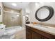 Bathroom featuring a tiled shower, granite countertop, and decorative mirror offers a stylish space at 560 Indigo Dr, Roswell, GA 30075