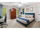 Bedroom features a ceiling fan, a large armoire, and a window overlooking the backyard at 560 Indigo Dr, Roswell, GA 30075