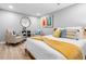 Bright bedroom featuring two chairs, modern wall art, a mirror, and a bed with decorative pillows and a throw blanket at 560 Indigo Dr, Roswell, GA 30075