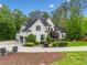 Charming home with a side entry garage, lush landscaping, and a circular driveway at 560 Indigo Dr, Roswell, GA 30075