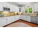 Kitchen featuring hardwood floors, white cabinets, granite countertops, and stainless steel appliances at 560 Indigo Dr, Roswell, GA 30075