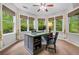 Bright home office with lots of natural light, a modern desk, a comfortable chair, and view of lush greenery at 560 Indigo Dr, Roswell, GA 30075