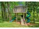 Fun backyard treehouse play area with a climbing wall, ladders, a slide, and a swing set for  at 560 Indigo Dr, Roswell, GA 30075