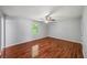 This bedroom features hardwood floors, a ceiling fan, and natural light at 6182 Silver Spur Dr, Lithonia, GA 30058