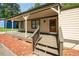 Inviting covered front porch with wooden decking and steps leading to the entrance door at 6182 Silver Spur Dr, Lithonia, GA 30058