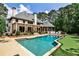 Backyard oasis featuring a pool, artificial turf putting green, hot tub, and covered patio at 1114 Waterford Green Pt, Marietta, GA 30068