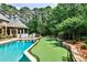 Expansive backyard with pool, putting green, hot tub, outdoor seating, and lush landscaping at 1114 Waterford Green Pt, Marietta, GA 30068