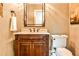 Charming half bathroom featuring a wood vanity with granite counters, framed mirror, and classic fixtures at 1114 Waterford Green Pt, Marietta, GA 30068