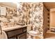 Bathroom featuring decorative toile wallpaper, dark vanity with granite countertop, toilet, and shower with curtain at 1114 Waterford Green Pt, Marietta, GA 30068