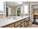 This bathroom has a double vanity, framed mirrors and windows, and neutral paint and cabinets at 1114 Waterford Green Pt, Marietta, GA 30068
