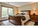 Cozy bedroom with a queen bed, side tables with lamps, neutral walls, and a large window with natural light at 1114 Waterford Green Pt, Marietta, GA 30068