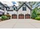 Three-car garage features decorative doors and exterior coach lights at 1114 Waterford Green Pt, Marietta, GA 30068