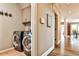 Convenient laundry room with modern washer and dryer, coat racks, and access to the main living area at 1114 Waterford Green Pt, Marietta, GA 30068
