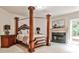 Main bedroom with a four-poster bed, fireplace with marble surround, and neutral carpet at 1114 Waterford Green Pt, Marietta, GA 30068