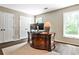 This office features a wooden desk, two windows, wood floors, and white trim and white paneled double doors at 1114 Waterford Green Pt, Marietta, GA 30068